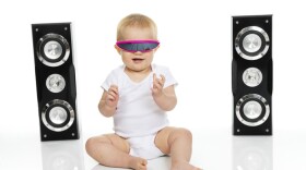 A baby with robot / 80's glasses listening to music