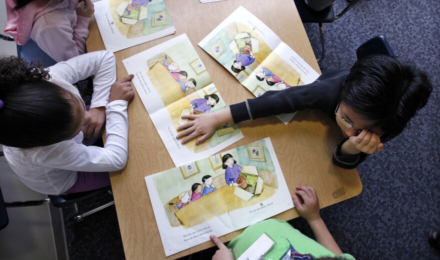 In this photo taken Wednesday, Feb. 6, 2013, Campbell Hill Elementary kindergarten students work on reading skills in Renton, Wash. Washington is one of two states (the other being Pennsylvania) that doesn't require kids to start their educations until age 8. A bill in the House would lower the mandatory age to 6, but would exempt home-schoolers, who wouldn't fall under the state's instructional supervision until age 8.(AP Photo/Elaine Thompson)