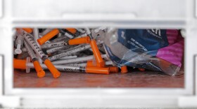 FILE - A box of needles collected at a homeless encampment at Ballard Commons Park is shown on May 4, 2020, in Seattle. Seattle Mayor Bruce Harrell is asking members of the city council who recently voted against adopting the state's controlled substance law to consider an amended plan. Harrell on Monday, July 31, 2023, offered a proposal that would align the city's code with new state law, making possession and public use of drugs such as fentanyl a gross misdemeanor. (AP Photo/Ted S. Warren, File)