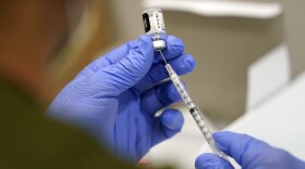 A health care worker fills a syringe with the Pfizer COVID-19 vaccine.