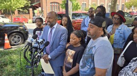 Thiru Vignarajah (center) speaks to reporters on Monday Aug. 12, 2024 surrounded by the family of Ronald Silver II