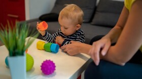 Closeup of baby and mom playing with toy,