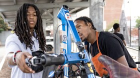 Quarron and Dice swap an old, worn seat from a client’s bike for a brand new one – and check out the gears to make sure everything’s running smoothly. Jessica Gallagher/The Baltimore Banner