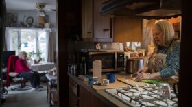 Nancy Rose, right, who contracted COVID-19 in 2021 and continues to exhibit long-haul symptoms including brain fog and memory difficulties, cooks for her mother, Amy Russell, left, at their home, Tuesday, Jan. 25, 2022, in Port Jefferson, N.Y. Rose, 67, said many of her symptoms waned after she got vaccinated, though she still has bouts of fatigue and memory loss. (AP Photo/John Minchillo)