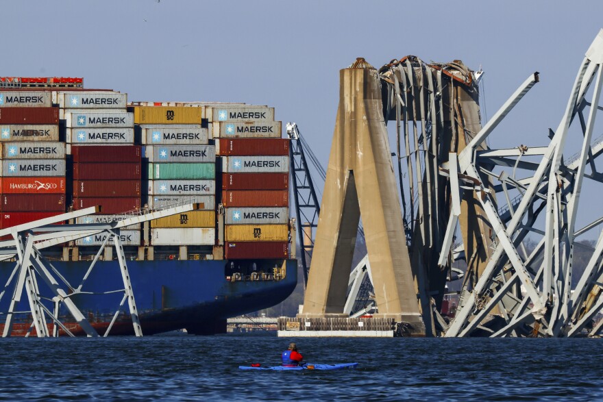 A kayaker looks on as the wreckage of the Francis Scott Key Bridge rests on the container ship Dali, Saturday, March 30, 2024, in Baltimore. (AP Photo/Julia Nikhinson)