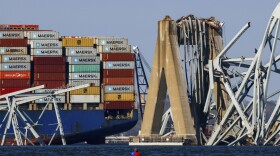 A kayaker looks on as the wreckage of the Francis Scott Key Bridge rests on the container ship Dali, Saturday, March 30, 2024, in Baltimore. (AP Photo/Julia Nikhinson)