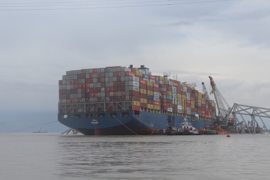 The Dali, the cargo vessel that struck a supportive pylon, causing the Francis Scott Key Bridge to collapse, is pictured with part of the wreckage of the bridge on April 4, 2024. Photo by Scott Maucione/WYPR.