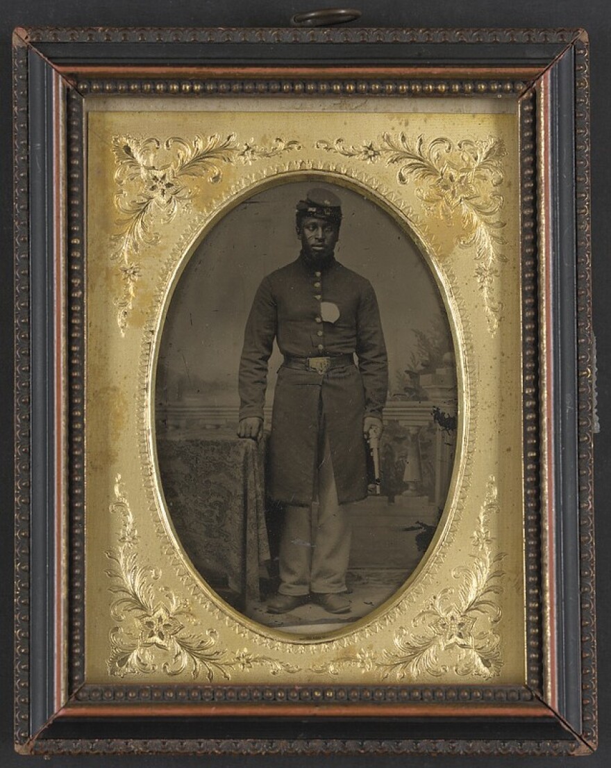 Sergeant Tom Strawn of Company B, 3rd U.S. Colored Troops Heavy Artillery Regiment, with revolver in front of painted backdrop showing balustrade and landscape credit: LOC/Flickr/Creative Commons