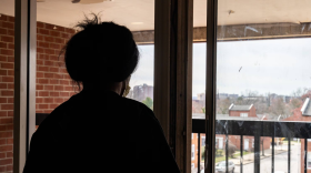 A Lanvale Street Apartment tenant who wishes to remain anonymous looks out a window of the building on Friday, March 8, 2024. Tenants have faced substandard housing conditions for years, but have struggled with getting the landlord to make sufficient repairs. (Kylie Cooper/The Baltimore Banner)