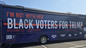 A navy-colored bus emblazoned with the phrases “I’m not with her” and “Black voters for Trump” received a cheer from the crowd of fewer than a dozen Black Republicans, many of them members of the local Republican Central Committee. Photo by Emily Hofstaedter/WYPR.