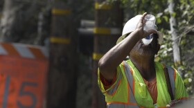 A construction worker drinks water while on a break from working on a street paving crew Friday, Sept. 1, 2017, in Orinda, Calif.  Dozens of cooling centers opened throughout California, schools let students out early and outdoor events were cancelled as temperatures soared from a heat wave expected to last through the Labor Day weekend. (AP Photo/Ben Margot)