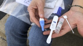 Brooke Parker displays an HIV testing kit in Charleston, W.Va. amid one of the nation's highest spikes of HIV cases.