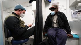 Nurse practitioner Bobby Harris, left, talks with patient Darryl Jackson during a visit inside a Baltimore City Health Department RV, Monday, March 20, 2023, in Baltimore. The Baltimore City Health Department's harm reduction program uses the RV to address the opioid crisis, which includes expanding access to medication assisted treatment by deploying a team of medical staff to neighborhoods with high rates of substance abuse and offering buprenorphine prescriptions. (AP Photo/Julio Cortez)