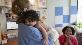 Capri Isidoro, of Ellicott City, Md., right, claps on hearing reassuring advice from Ann Faust, an International Board Certified Lactation Consultant (IBCLC), holding Isidoro's one-month-old baby Charlotte, Monday, May 23, 2022, in Columbia, Md., during a lactation consult at Baby and Me Lactation Services. Baby Charlotte was delivered via emergency c-section and given formula by hospital staff. Isidoro has been having trouble with breastfeeding and has been searching for a formula that her daughter can tolerate well. "If all things were equal I would feed her with formula and breastmilk," says Isidoro, "but the formula shortage is so scary. I worry I won't be able to feed my child." (AP Photo/Jacquelyn Martin)