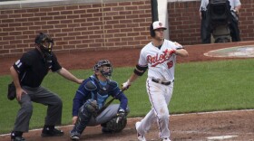  Chris Davis at bat with a catcher and umpire behind him.