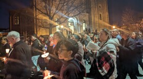 A crowd of a few hundred people process with candles around Sacred Heart to honor the lives of the six construction workers killed on the Key Bridge.