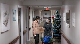 FILE - Tina Sandri, CEO of Forest Hills of DC senior living facility, left, helps resident Courty Andrews back to her room, Dec. 8, 2022, in Washington. The federal government will, for the first time, dictate staffing levels at nursing homes, the Biden administration said Friday, Sept. 1, 2023, responding to systemic problems bared by mass COVID deaths. (AP Photo/Nathan Howard, File)