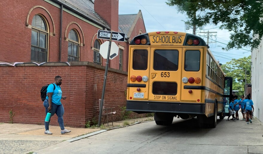 Students get on a bus in Baltimore City in late July.