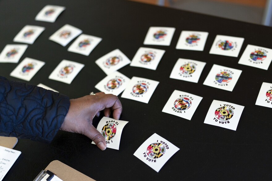 A voter gets a voting sticker after casting her ballot at Galway Elementary School, during Election Day on Tuesday, Nov. 8, 2022, in Silver Spring, Md. ( AP Photo/Jose Luis Magana)