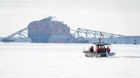 A U.S. Coast Guard boat heads toward the collapsed Francis Scott Key Bridge wreckage seen from Fort McHenry on March 26, 2024. Photo: Ulysses Muñoz/The Baltimore Banner