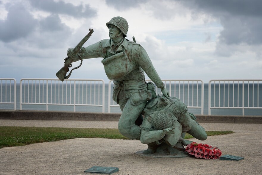 This statue by artist Yannec Tomada commemorates the 116th Infantry Regimental Combat Team, who stormed Omaha Beach on D-Day in the beginning of the liberation of Europe. The plaque reads: Ever Forward In commemoration of the determined effort by the soldiers of the 29th Division's 116th Infantry Regimental Combat Team who landed the morning of June 6, 1944 on this section of Omaha Beach, known as Exit D-1, to open the Vierville Draw behind you to begin the liberation of Europe.