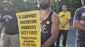 Larrington Scott was one of a few dozen workers who braved the heat to protest outside Reedbird sanitation yard Wednesday.