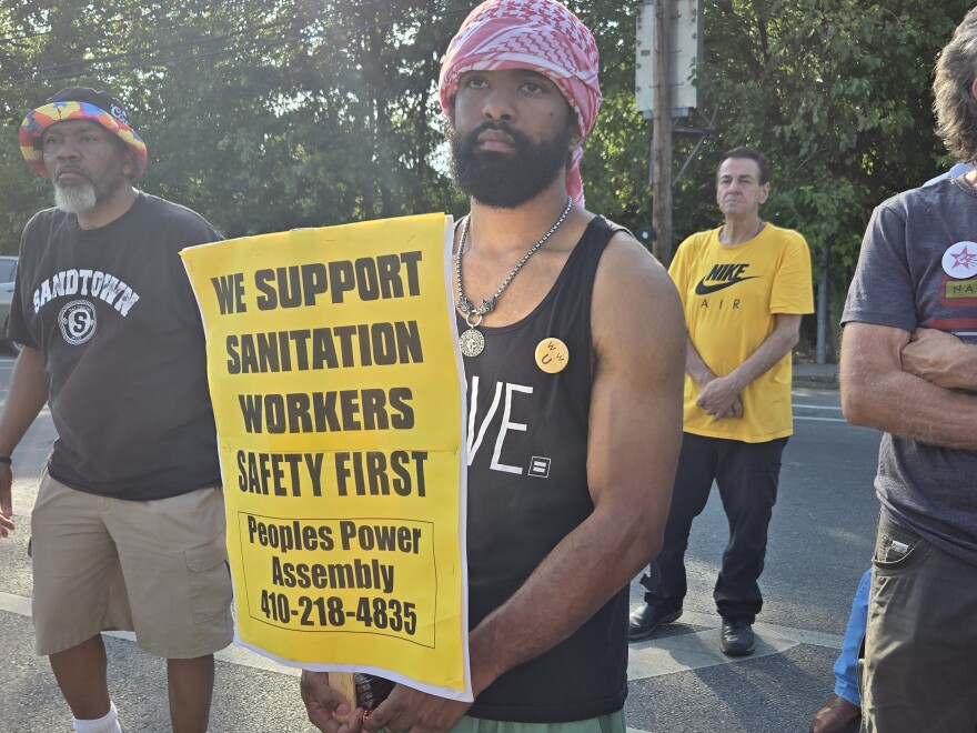 Larrington Scott was one of a few dozen workers who braved the heat to protest outside Reedbird sanitation yard Wednesday.