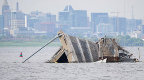 Wreckage from the collapsed Francis Scott Key bridge is seen in front of the Baltimore City Skyline from a boat in the Patapsco River on April 25, 2024. (Ulysses Muñoz/The Baltimore Banner) 