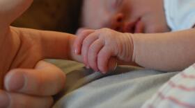 Holding hands. The warmth and comfort of human touch is an essential stimulus for the newborn child. (Photo by Wayne Evans, CCO via Wikimedia Commons)