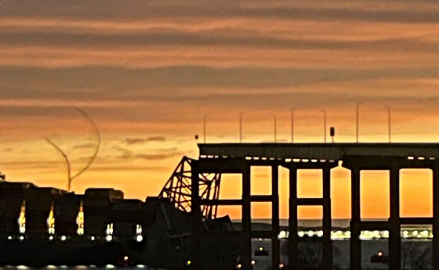 The sun rises over the collapsed portion of the Francis Scott Key Bridge in Baltimore on Tuesday.