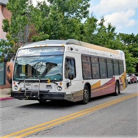 An MTA bus rolls through Patterson Park in East Baltimore. (Photo credit Ulysses Muñoz, The Baltimore Banner)