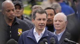 Transportation Secretary Pete Buttigieg, at podium, accompanied by officials including Maryland Gov. Wes Moore and Sen. Ben Cardin, D-Md., speaks during a news conference near the scene where a container ship collided with a support on the Francis Scott Key Bridge, in Dundalk, Md., Tuesday, March 26, 2024. (AP Photo/Matt Rourke)