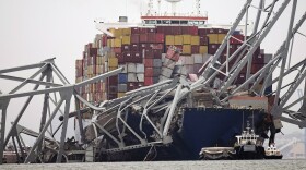 A cargo ship is stuck under the part of the structure of the Francis Scott Key Bridge after the ship hit the bridge Wednesday, March 27, 2024, in Baltimore, Md. (AP Photo/Steve Helber)