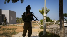 Isreali soldiers patrol next to houses damaged by Hamas militants at Kibbutz Kissufim in southern Israel, Saturday, Oct. 21, 2023. The Kibbutz was stormed by Hamas militants from the nearby Gaza Strip on Oct. 7, when they killed and captured many Israelis. (AP Photo/Francisco Seco)