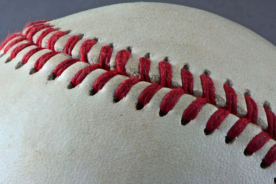 Close up of red stitching on a white baseball.