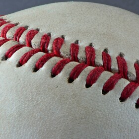 Close up of red stitching on a white baseball.