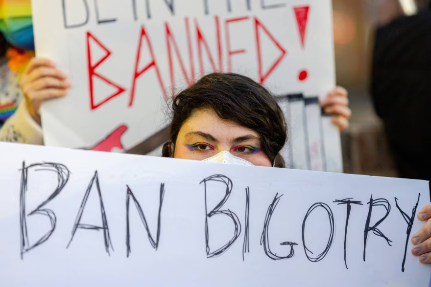 Gabriella Monroe holds a poster that says “Ban Bigotry Not Books” outside Howard County’s Central Branch library in Columbia on Feb. 26.