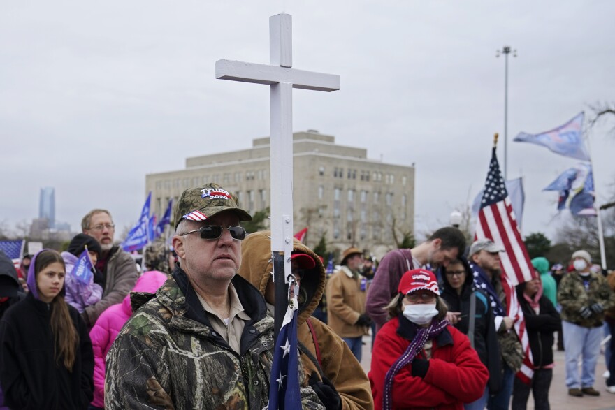 Kenny Womack, of Edmond, Okla., holds a cross at a Trump rally at the state Capitol, Wednesday, Jan. 6, 2021, in Oklahoma City. (AP Photo/Sue Ogrocki)