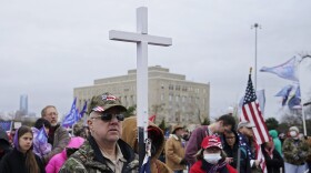 Kenny Womack, of Edmond, Okla., holds a cross at a Trump rally at the state Capitol, Wednesday, Jan. 6, 2021, in Oklahoma City. (AP Photo/Sue Ogrocki)