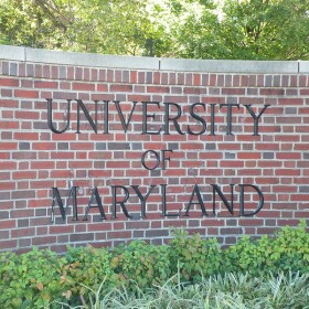 Brick sign reading "University of Maryland" with plants in front