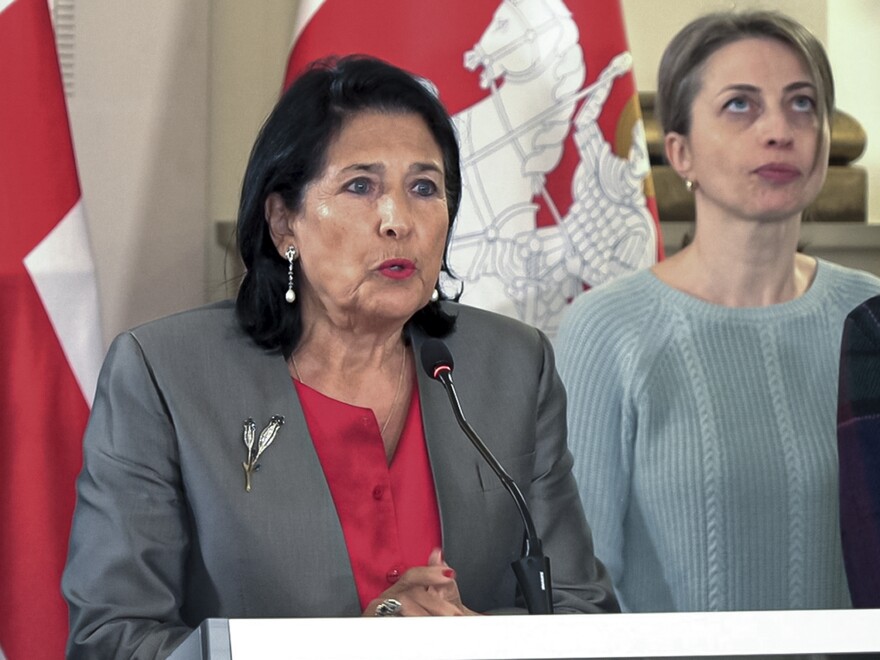 In this photo taken from video, Georgian President Salome Zourabichvili, left, speaks to the media as speaks to the media as and Nana Malashkhia, who leads the Coalition for Change parliament list, right, stands near, after the parliamentary election in Tbilisi, Georgia, on Sunday.