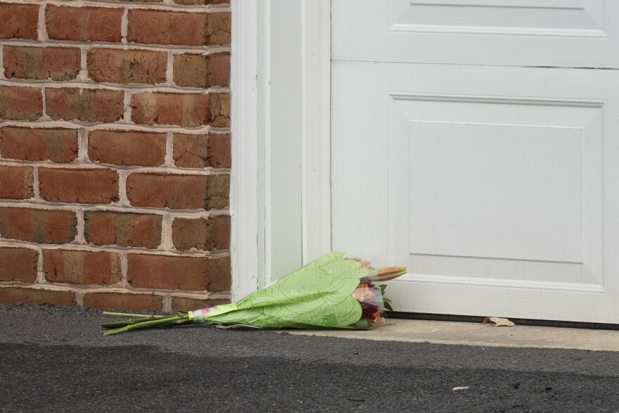 Flowers are placed next to the garage door in the drive way of the home of Maryland circuit court Judge Andrew Wilkinson, Friday, Oct. 20. 2023, in Hagerstown, Md. Pedro Argote is suspected of gunning down the judge in his driveway hours after he ruled against him in a divorce case. The Washington County Sheriff's Office said in a statement that the silver Mercedes SUV that Argote was believed to be driving has been located in Williamsport, about 8 miles (13 kilometers) southwest of Hagerstown, where the judge was shot outside his home. (AP Photo/Jon Elswick)