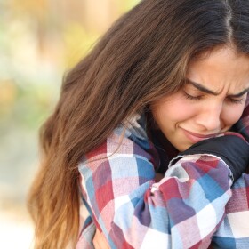 Close up of a teenager girl worried and sad crying outdoors