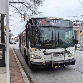 An MTA CityLink Navy bus pulls up on Eastern Avenue. Students from Cristo Rey Jesuit High School ride this line to & from school. (photo credit Aaron Henkin / WYPR