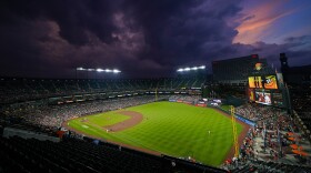 Clouds roll in over Oriole Park at Camden Yards in the sixth inning of a baseball game between the Baltimore Orioles and the Cincinnati Reds, Tuesday, June 27, 2023, in Baltimore. (AP Photo/Julio Cortez)