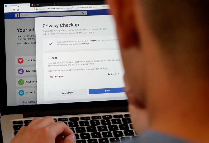 FILE - In this March 26, 2018, file photo, a man poses for photos in front of a computer showing Facebook ad preferences pages in San Francisco. If you’ve made changes to how you use social media since Facebook’s Cambridge Analytica privacy debacle, you’re not alone. A new poll by the Associated Press-NORC Center for Public Affairs Research found that 7 out of 10 of online adults who’ve heard of the Cambridge Analytica scandal have changed their behavior on social media. (AP Photo/Jeff Chiu, File)