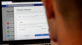 FILE - In this March 26, 2018, file photo, a man poses for photos in front of a computer showing Facebook ad preferences pages in San Francisco. If you’ve made changes to how you use social media since Facebook’s Cambridge Analytica privacy debacle, you’re not alone. A new poll by the Associated Press-NORC Center for Public Affairs Research found that 7 out of 10 of online adults who’ve heard of the Cambridge Analytica scandal have changed their behavior on social media. (AP Photo/Jeff Chiu, File)