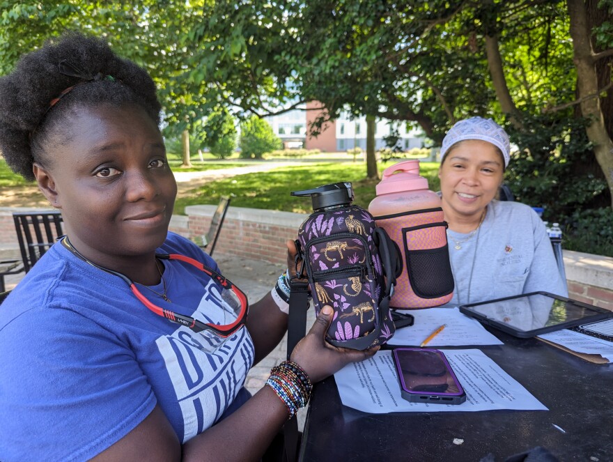 Margie Rodriguez (right) has ended up buying water bottles for some of her teammates like Admire Stewart (left) so that workers can be hydrated on the job. Rodriguez says sometimes the water in the dorms can come out murky or brown. Photo by Emily Hofstaedter/WYPR.